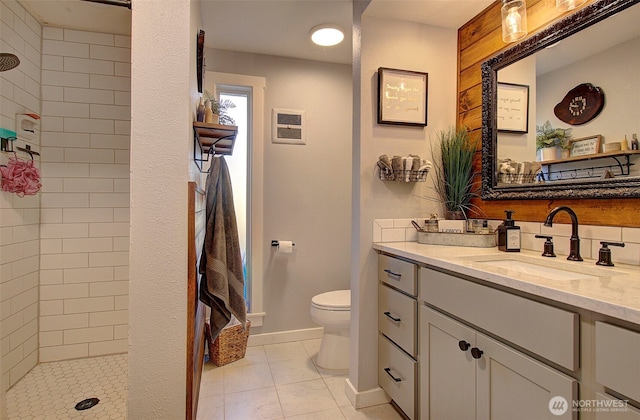 10012 NE 39th St, Vancouver, WA 98662 - full bathroom featuring toilet, a tile shower, vanity, baseboards, and tile patterned floors