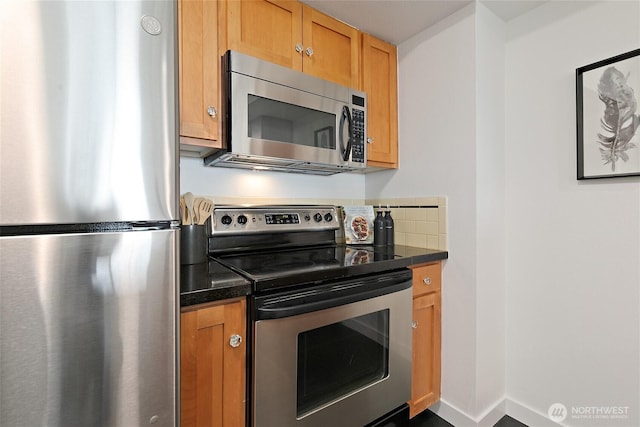 1909 10th Ave W Unit 203, Seattle, WA 98119 - kitchen featuring appliances with stainless steel finishes, dark countertops, and brown cabinets