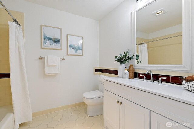 1909 10th Ave W Unit 203, Seattle, WA 98119 - full bath featuring toilet, vanity, tile patterned floors, baseboards, and shower / bath combination with curtain