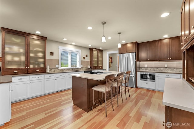 1605 Donovan Ave, Bellingham, WA 98225 - kitchen featuring stainless steel appliances, light wood-style flooring, backsplash, a breakfast bar, and recessed lighting