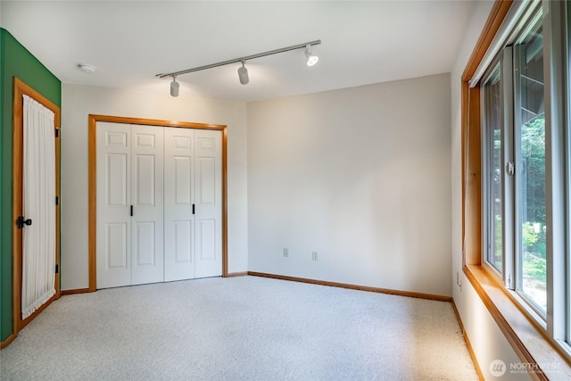5419 Quail Run, Blaine, WA 98230 - unfurnished bedroom featuring track lighting, multiple windows, carpet floors, and baseboards