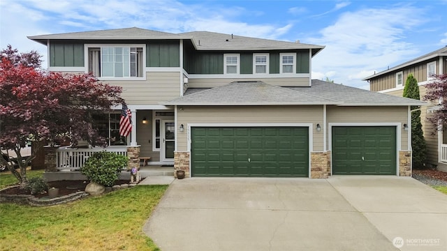 15315 91st Ave SE, Yelm, WA 98597 - view of front of house featuring concrete driveway, stone siding, a garage, board and batten siding, and a shingled roof