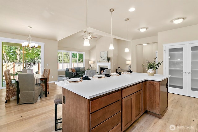 7391 Mirasett St SW Lot 42, Tumwater, WA 98512 - kitchen with light wood finished floors, a lit fireplace, brown cabinets, open floor plan, and a ceiling fan