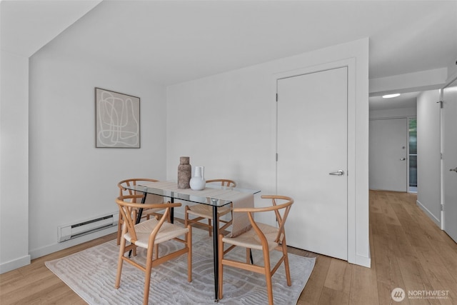 1601 Taylor Ave N Unit 303, Seattle, WA 98109 - dining space featuring a baseboard radiator, light wood-type flooring, and baseboards