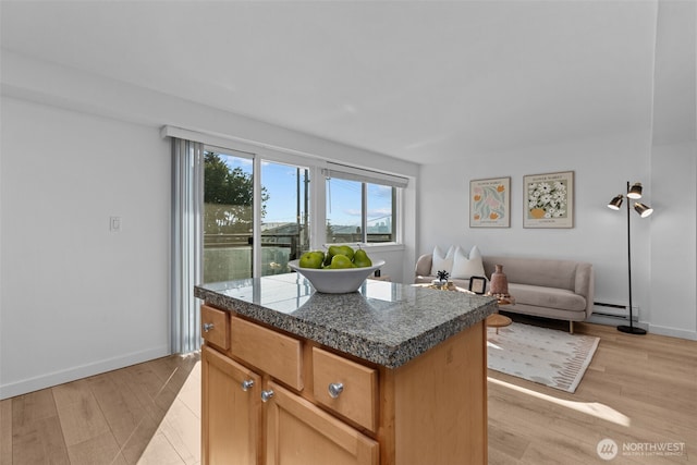 1601 Taylor Ave N Unit 303, Seattle, WA 98109 - kitchen featuring tile countertops, a baseboard radiator, light wood-style floors, and open floor plan