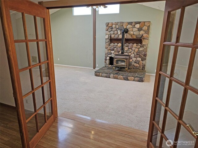20025 Carper Rd SW, Rochester, WA 98579 - unfurnished living room with a wood stove, french doors, and baseboards