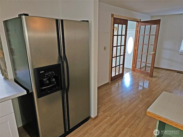 20025 Carper Rd SW, Rochester, WA 98579 - kitchen with stainless steel fridge with ice dispenser, french doors, light wood finished floors, and baseboards