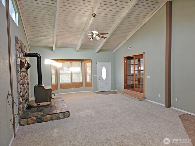 20025 Carper Rd SW, Rochester, WA 98579 - unfurnished living room featuring a wood stove, carpet, baseboards, ceiling fan, and wooden ceiling with exposed beams