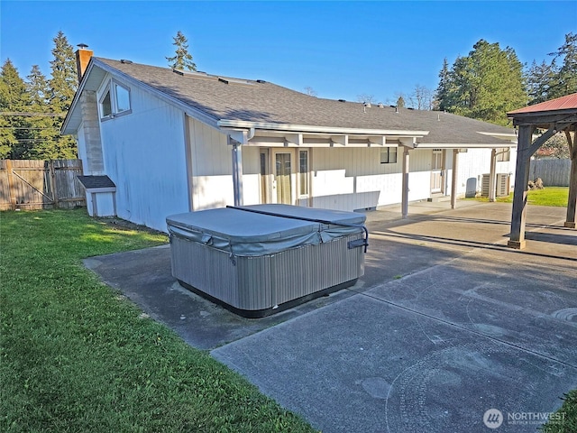 20025 Carper Rd SW, Rochester, WA 98579 - back of house featuring a hot tub, a chimney, a patio area, and a shingled roof