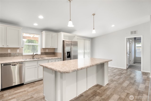 133 Broad St W, Bremerton, WA 98312 - kitchen featuring stainless steel appliances, recessed lighting, a center island, white cabinetry, and decorative light fixtures