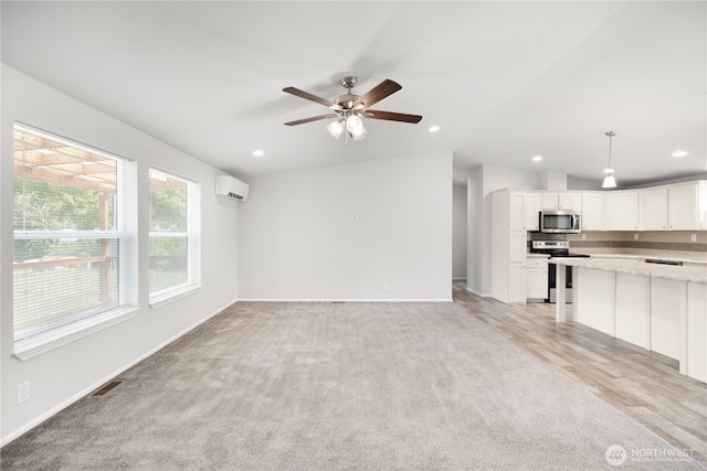133 Broad St W, Bremerton, WA 98312 - unfurnished living room featuring a wall unit AC, light carpet, recessed lighting, and a ceiling fan