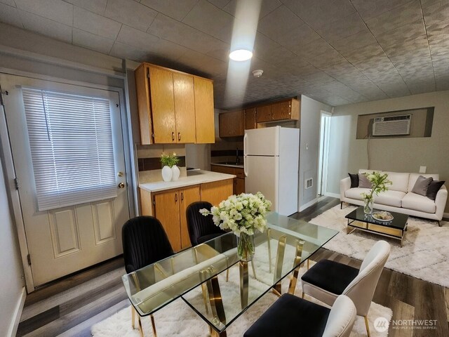124 W Shoshone St, Pasco, WA 99301 - dining space with wood finished floors, a wall mounted air conditioner, and baseboards
