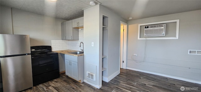 124 W Shoshone St, Pasco, WA 99301 - kitchen featuring freestanding refrigerator, black range with electric stovetop, a sink, a wall mounted air conditioner, and dark wood-style floors