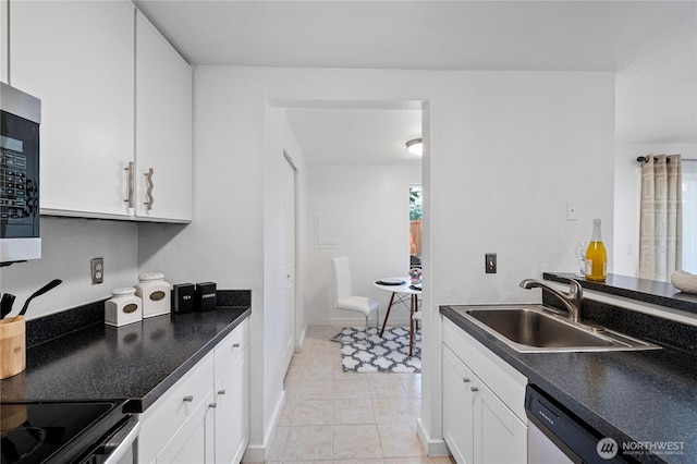 4721 176th St SW Unit G7, Lynnwood, WA 98037 - kitchen featuring a sink, white cabinetry, dark countertops, baseboards, and light tile patterned floors