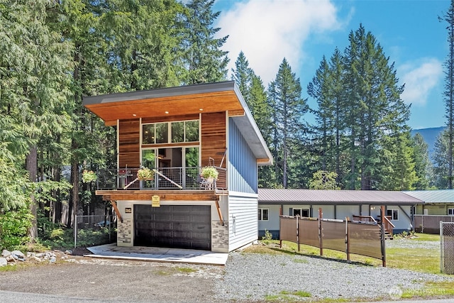 118 Silver Tip Ln, Packwood, WA 98361 - contemporary house featuring driveway, a balcony, stone siding, and a garage