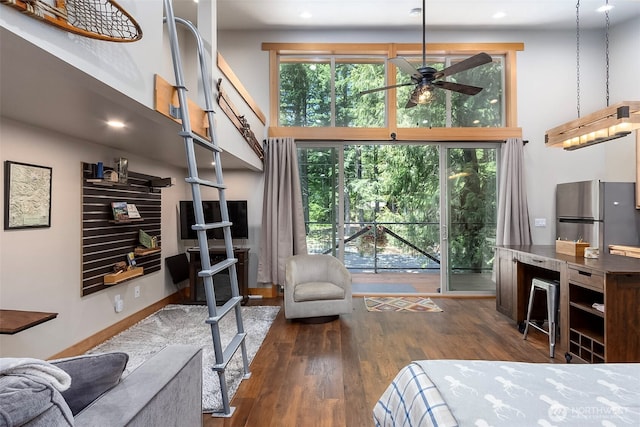 118 Silver Tip Ln, Packwood, WA 98361 - bedroom featuring a towering ceiling, freestanding refrigerator, wood finished floors, multiple windows, and recessed lighting