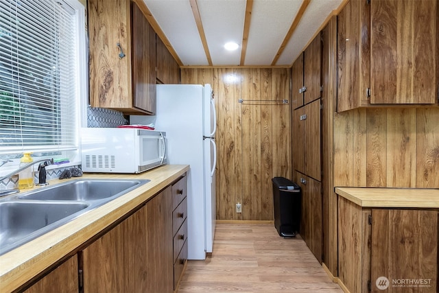 118 Silver Tip Ln, Packwood, WA 98361 - kitchen featuring white microwave, light wood-style floors, brown cabinetry, and wooden walls