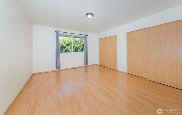 2715 99th Ave NE, Lake Stevens, WA 98258 - unfurnished bedroom with multiple closets and light wood finished floors