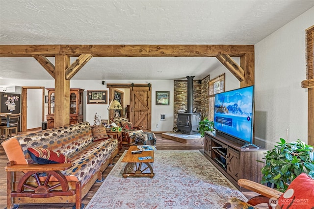 152 Simme Valley Ln, Winlock, WA 98596 - living room featuring a textured ceiling, wood finished floors, a barn door, and a wood stove