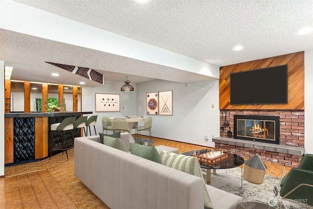 4012 NE 197th St, Lake Forest Park, WA 98155 - living room featuring a textured ceiling, a fireplace, recessed lighting, and a bar