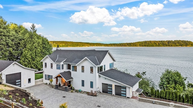 9418 165th Avenue Ct SW, Longbranch, WA 98351 - view of front facade with a water view, a shingled roof, board and batten siding, a forest view, and an outdoor structure