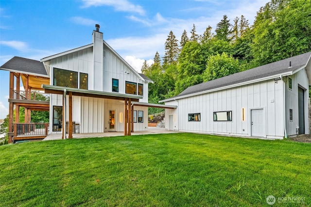 9418 165th Avenue Ct SW, Longbranch, WA 98351 - rear view of house featuring board and batten siding, a patio, a chimney, and a yard