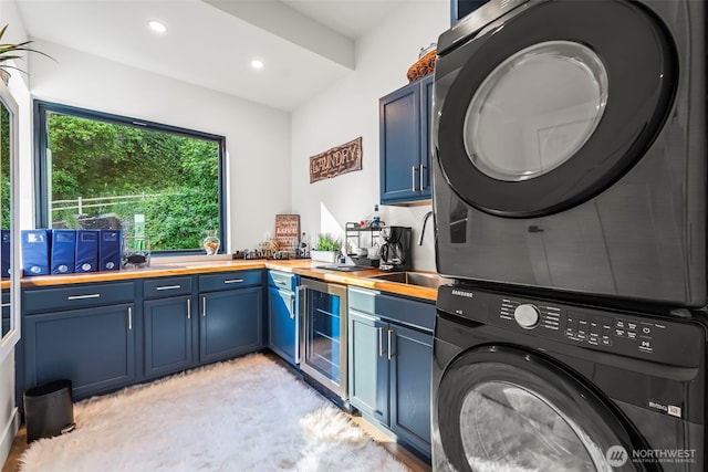 9418 165th Avenue Ct SW, Longbranch, WA 98351 - kitchen with stacked washer / drying machine, wood counters, blue cabinetry, beverage cooler, and recessed lighting