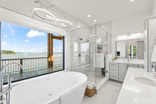 9418 165th Avenue Ct SW, Longbranch, WA 98351 - full bathroom with vanity, a freestanding tub, a marble finish shower, a water view, and marble tiled flooring