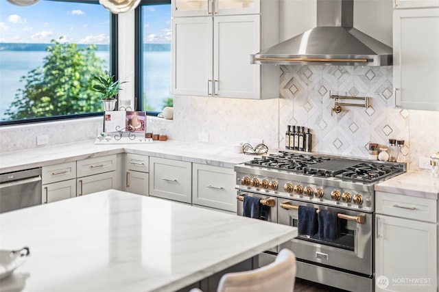 9418 165th Avenue Ct SW, Longbranch, WA 98351 - kitchen featuring stainless steel appliances, wall chimney range hood, backsplash, white cabinetry, and healthy amount of natural light