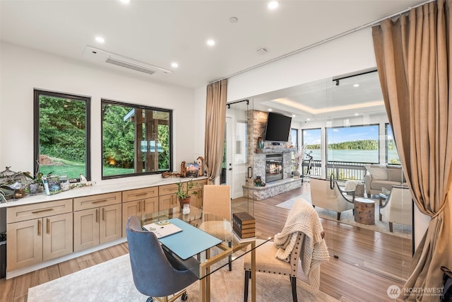 9418 165th Avenue Ct SW, Longbranch, WA 98351 - dining space with a fireplace, recessed lighting, light wood-style flooring, and a raised ceiling