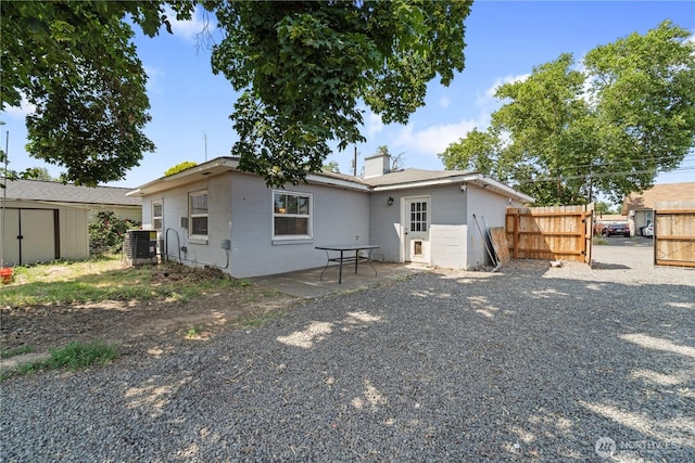 1618 Walla Walla Ave, Walla Walla, WA 99362 - back of house featuring concrete block siding, a chimney, and central AC unit