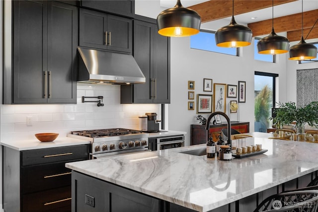 204 Moon River Vw SW, Mattawa, WA 99349 - kitchen with under cabinet range hood, stainless steel range, healthy amount of natural light, decorative backsplash, and a high ceiling