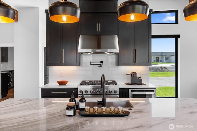 204 Moon River Vw SW, Mattawa, WA 99349 - kitchen with wall chimney exhaust hood, appliances with stainless steel finishes, tasteful backsplash, and dark cabinets