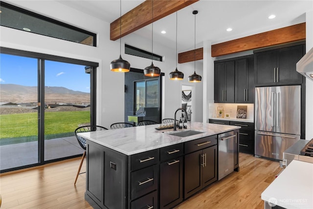 204 Moon River Vw SW, Mattawa, WA 99349 - kitchen with stainless steel appliances, dark cabinets, beamed ceiling, a kitchen breakfast bar, and light wood-type flooring