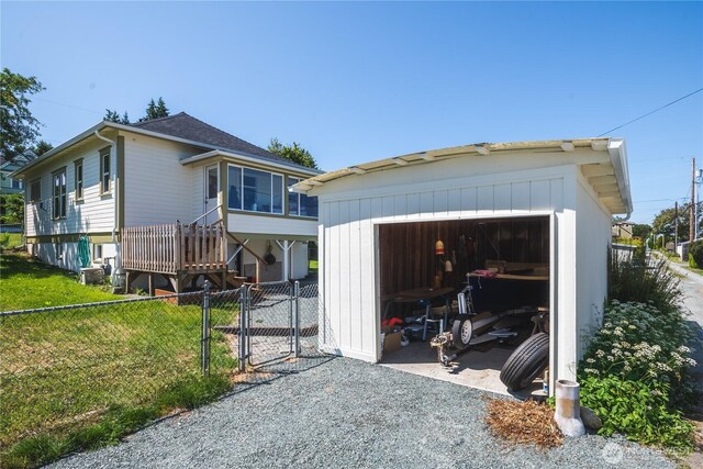 1612 7th St, Anacortes, WA 98221 - view of front of home featuring a garage, a gate, an outbuilding, driveway, and roof with shingles