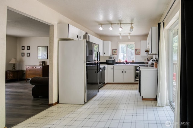 401 Draconis Ave SE, Ocean Shores, WA 98569 - kitchen with freestanding refrigerator, stainless steel microwave, white cabinets, dishwasher, and a sink