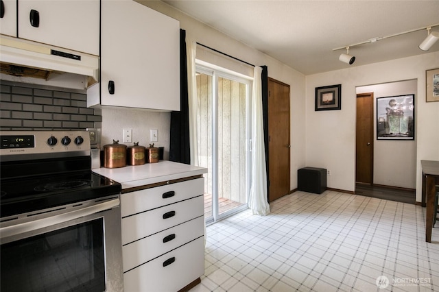 401 Draconis Ave SE, Ocean Shores, WA 98569 - kitchen with stainless steel electric stove, under cabinet range hood, light countertops, white cabinets, and tasteful backsplash