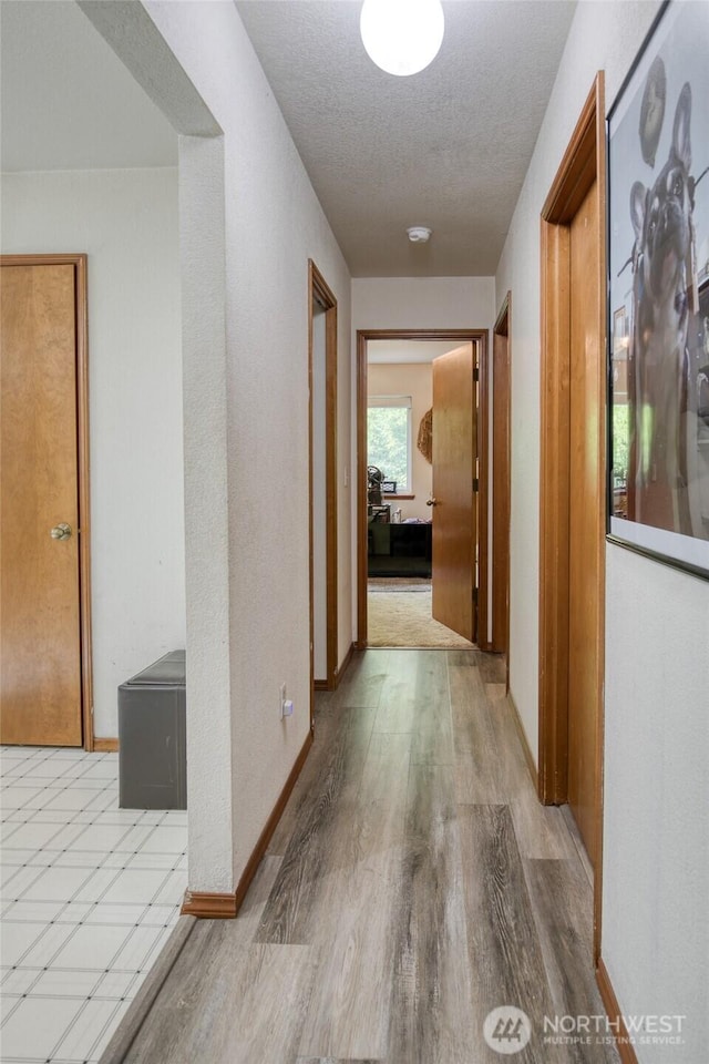 401 Draconis Ave SE, Ocean Shores, WA 98569 - corridor featuring wood finished floors, a textured ceiling, and baseboards