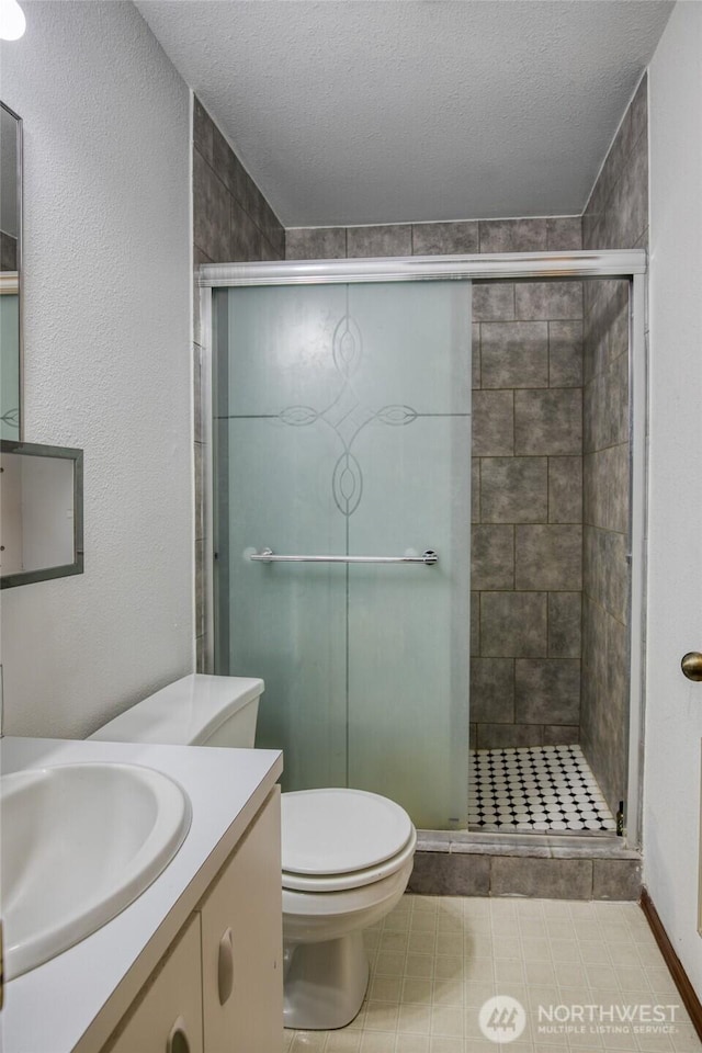 401 Draconis Ave SE, Ocean Shores, WA 98569 - bathroom with toilet, vanity, a shower stall, a textured ceiling, and tile patterned floors