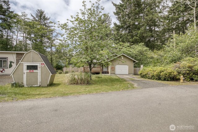 401 Draconis Ave SE, Ocean Shores, WA 98569 - view of front of house featuring asphalt driveway, view of scattered trees, and a garage