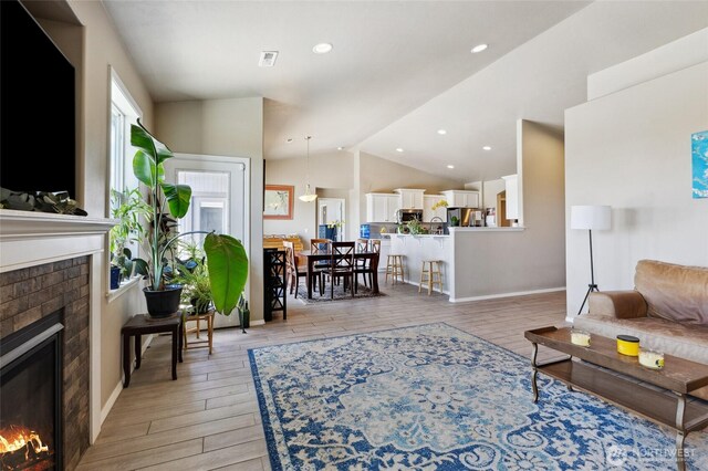 7186 16th Rd NE, Moses Lake, WA 98837 - living room featuring a brick fireplace, lofted ceiling, light wood-type flooring, baseboards, and recessed lighting