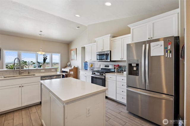 7186 16th Rd NE, Moses Lake, WA 98837 - kitchen featuring appliances with stainless steel finishes, a sink, lofted ceiling, wood finish floors, and a kitchen island