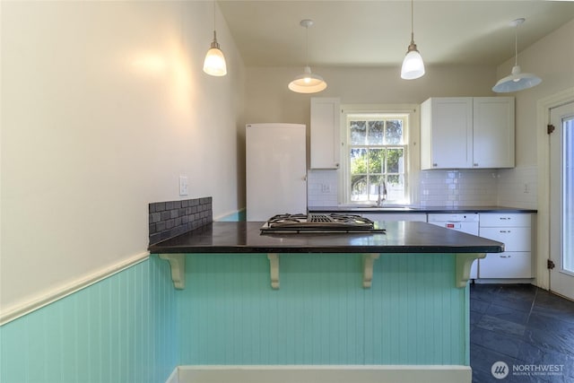 244 Marcus St, Walla Walla, WA 99362 - kitchen featuring dark countertops, decorative backsplash, and a breakfast bar area