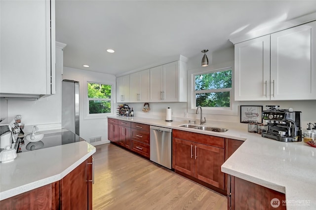 10825 Marine View Dr SW, Seattle, WA 98146 - kitchen with appliances with stainless steel finishes, a sink, light wood-style floors, white cabinetry, and recessed lighting
