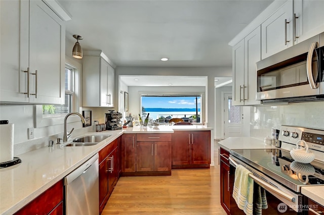 10825 Marine View Dr SW, Seattle, WA 98146 - kitchen featuring stainless steel appliances, a sink, light countertops, light wood-style floors, and recessed lighting