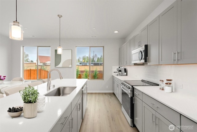 13307 SE 238th Pl Unit 11, Kent, WA 98042 - kitchen featuring stainless steel appliances, a sink, gray cabinets, light wood-style floors, and light countertops