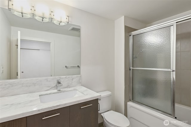 2911 2nd Ave Unit 522, Seattle, WA 98121 - bathroom featuring vanity, combined bath / shower with glass door, and toilet