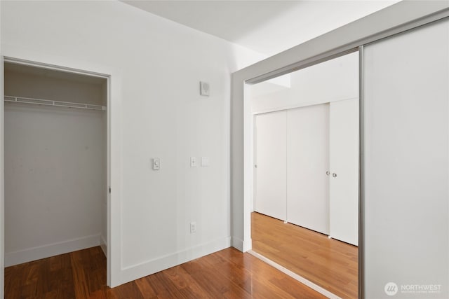 2911 2nd Ave Unit 522, Seattle, WA 98121 - unfurnished bedroom featuring wood finished floors and baseboards