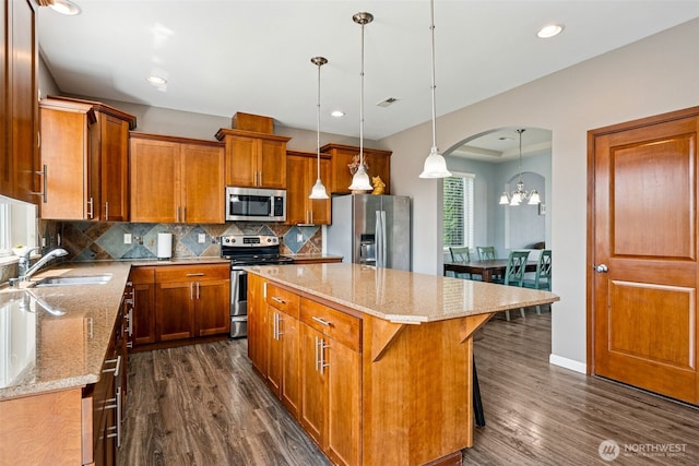10089 Jensen Dr SE, Yelm, WA 98597 - kitchen with appliances with stainless steel finishes, dark wood finished floors, brown cabinetry, backsplash, and recessed lighting