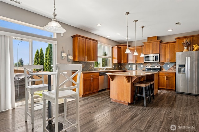 10089 Jensen Dr SE, Yelm, WA 98597 - kitchen with appliances with stainless steel finishes, brown cabinetry, dark wood-type flooring, and recessed lighting